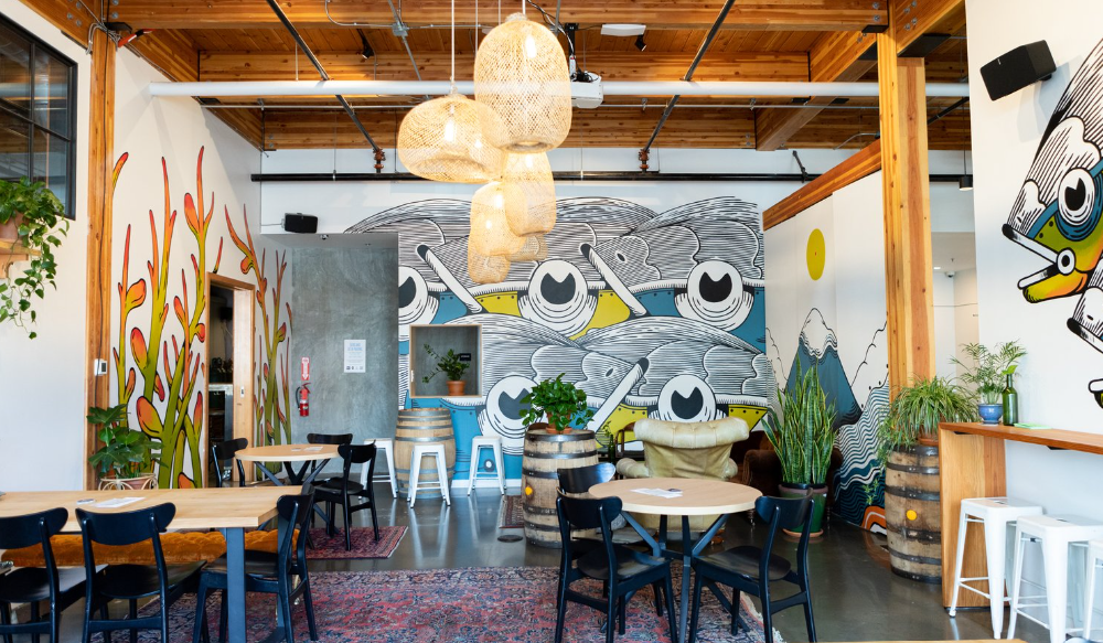 Aslan Brewing's side room with colorful murals and hanging light fixtures