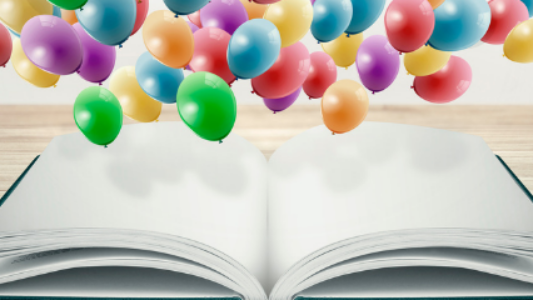 Colorful balloons falling onto an open book.